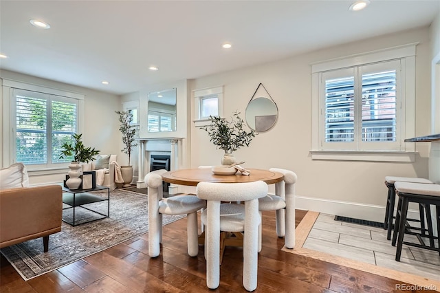 dining space featuring recessed lighting, baseboards, hardwood / wood-style flooring, and a fireplace