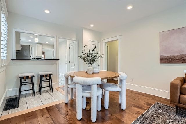 dining space featuring baseboards, recessed lighting, and wood finished floors