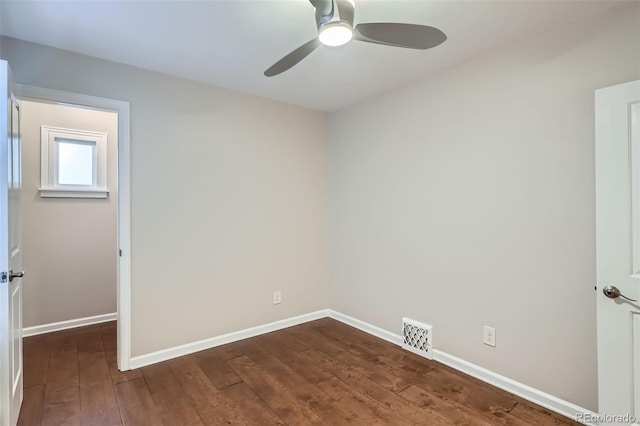 empty room featuring baseboards, a ceiling fan, dark wood finished floors, and visible vents
