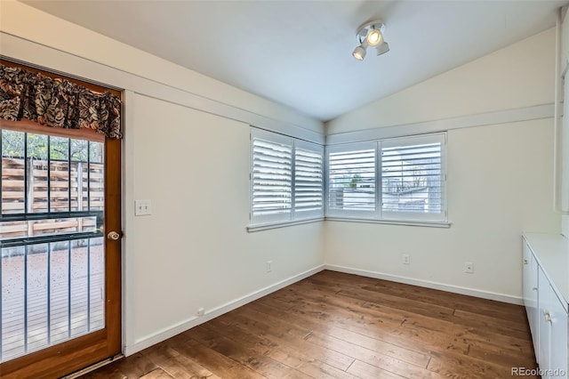 interior space featuring baseboards, hardwood / wood-style flooring, and lofted ceiling
