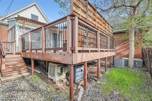 deck with stairs, ac unit, and cooling unit