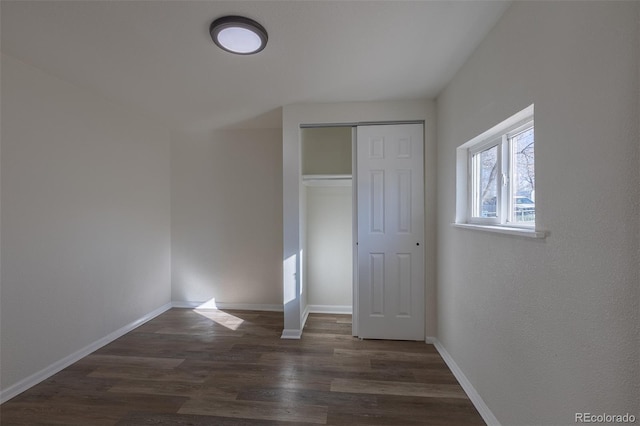 unfurnished bedroom featuring a closet, baseboards, and wood finished floors