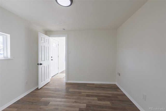 empty room featuring baseboards and wood finished floors