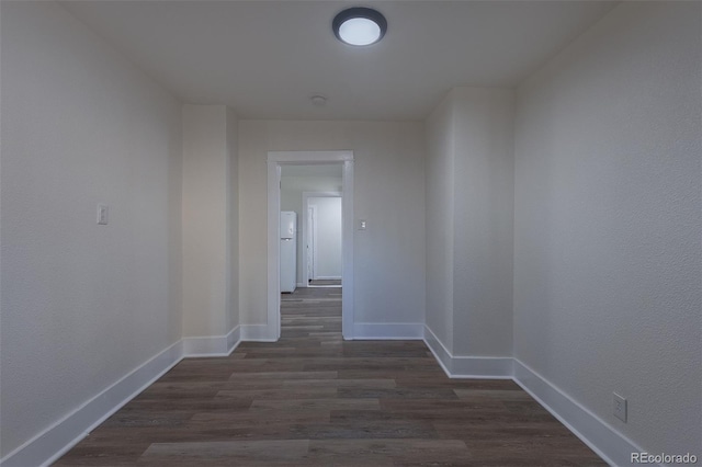 hall with dark wood finished floors and baseboards