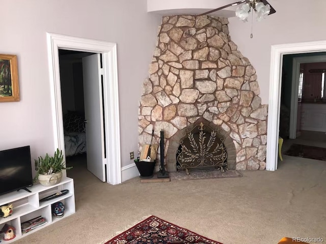 living room with carpet and a stone fireplace