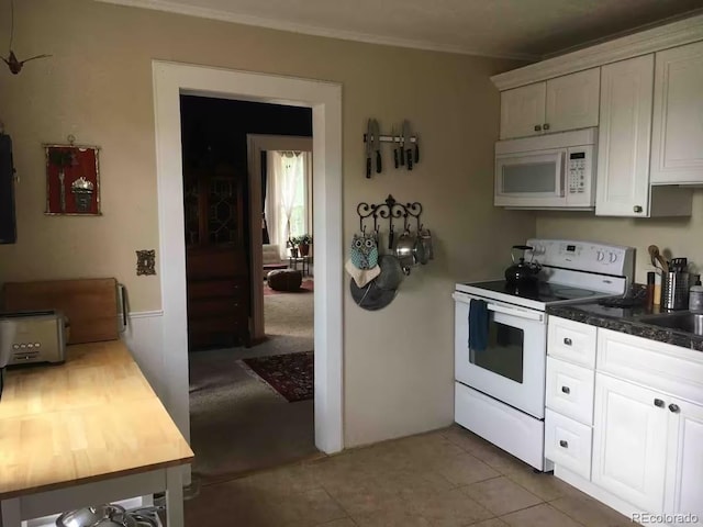 kitchen with white cabinetry, sink, white appliances, and light tile patterned flooring