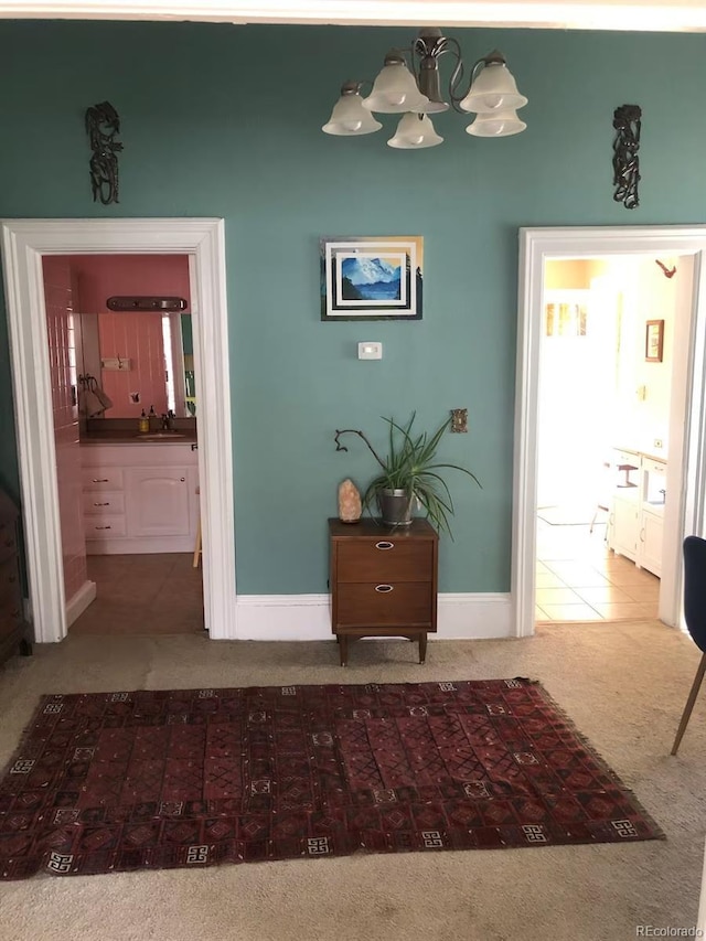 corridor featuring sink, a chandelier, and carpet flooring