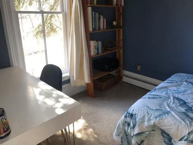 bedroom featuring dark colored carpet, multiple windows, and a baseboard heating unit