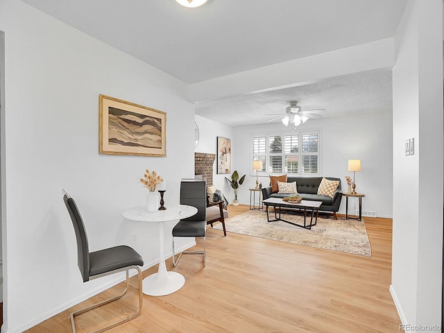 5225 Beech St, Arvada, CO 80002 - living room featuring baseboards, light wood-style flooring, ceiling fan, and a textured ceiling