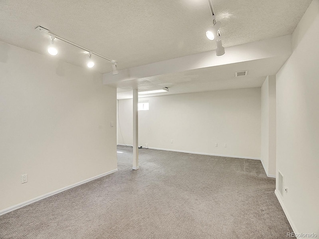 5225 Beech St, Arvada, CO 80002 - basement featuring track lighting, carpet flooring, a textured ceiling, and baseboards