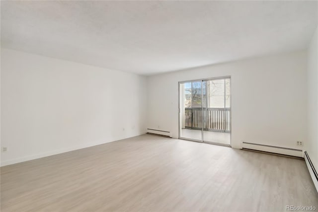 empty room with light wood-type flooring and baseboard heating