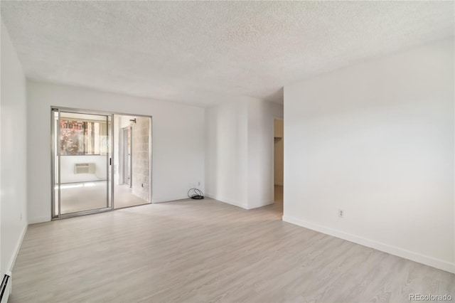 unfurnished room featuring baseboards, a textured ceiling, light wood finished floors, and a baseboard radiator