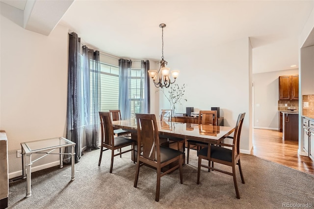 carpeted dining room with a chandelier