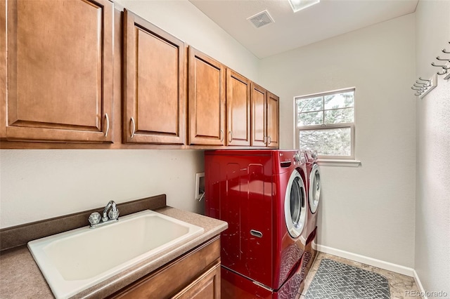 laundry room featuring cabinets, tile patterned flooring, washing machine and clothes dryer, and sink