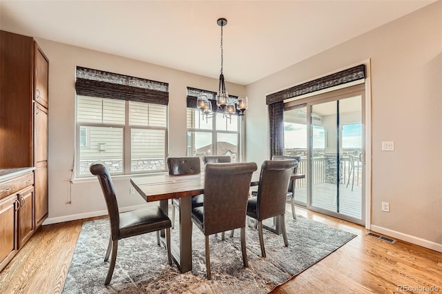 dining area featuring light wood-type flooring and a chandelier