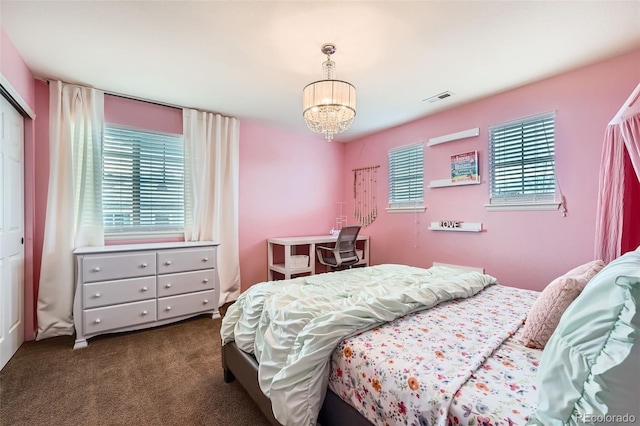 carpeted bedroom with a chandelier