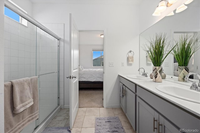 bathroom featuring tile patterned floors, a shower with door, and vanity