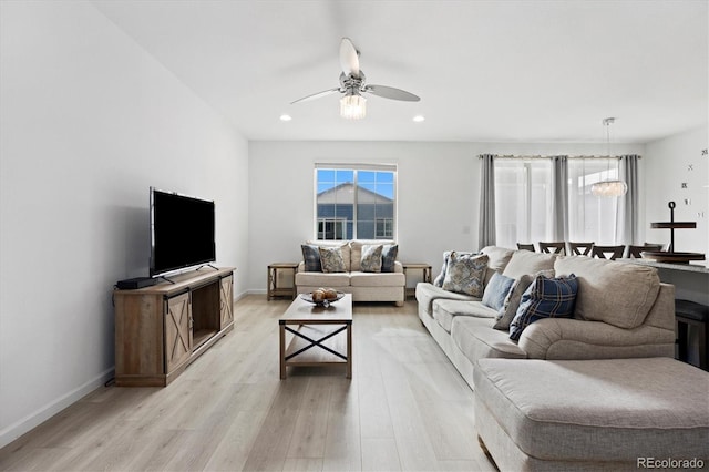 living room featuring light hardwood / wood-style flooring and ceiling fan