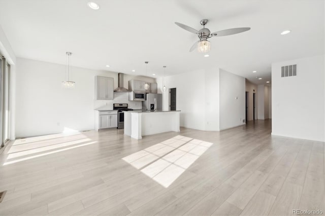 unfurnished living room featuring ceiling fan and light wood-type flooring