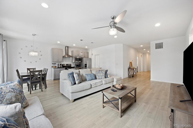 living room with ceiling fan and light hardwood / wood-style flooring