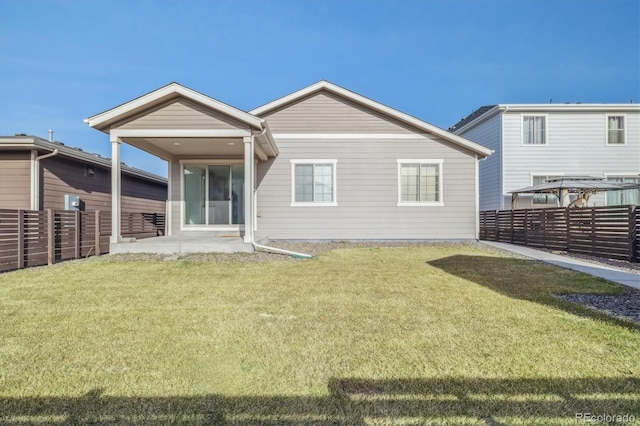 rear view of property featuring a yard and a patio