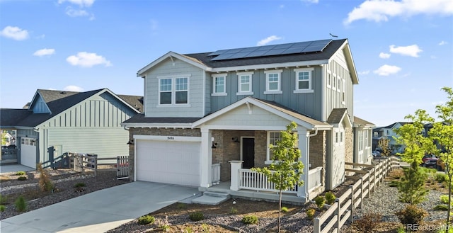 view of front of property with fence, driveway, a porch, board and batten siding, and roof mounted solar panels