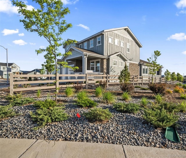 view of side of property featuring a fenced front yard and board and batten siding