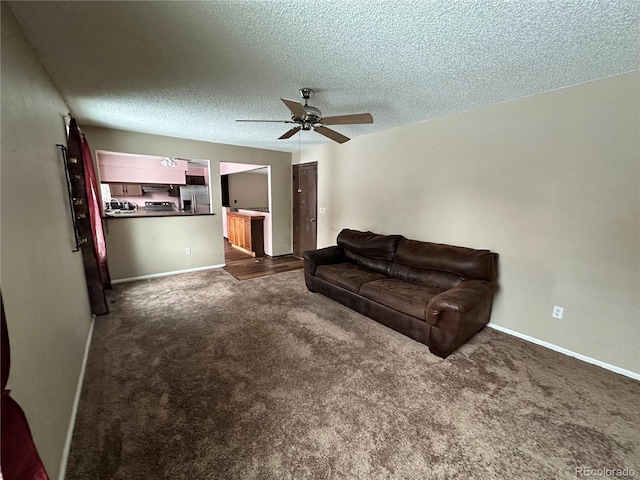 living room featuring dark colored carpet, a textured ceiling, and ceiling fan