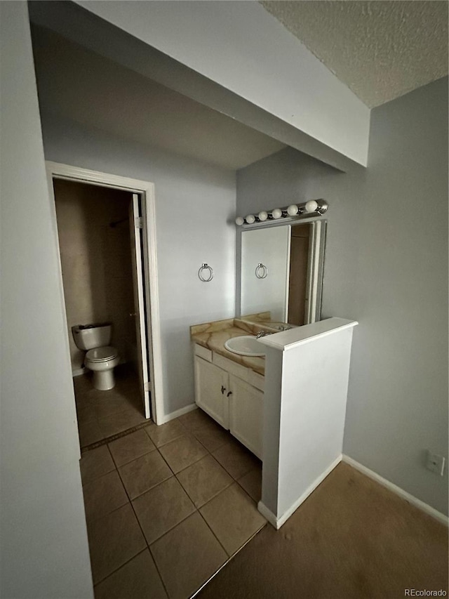 bathroom with tile patterned floors, vanity, toilet, and a textured ceiling