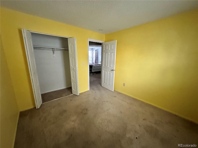 unfurnished bedroom with light colored carpet, a textured ceiling, and a closet