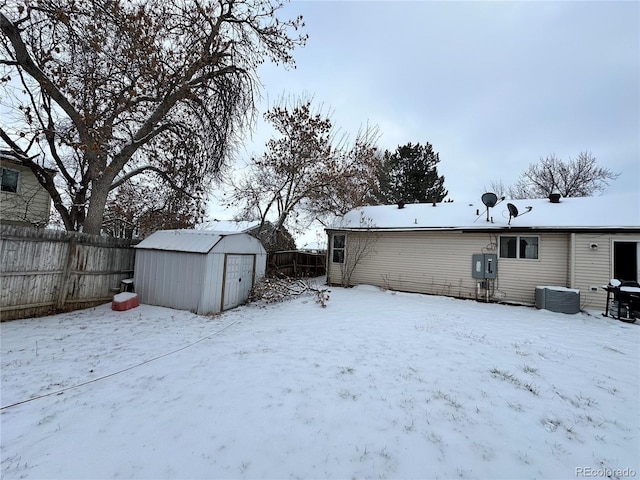 yard layered in snow featuring a storage unit