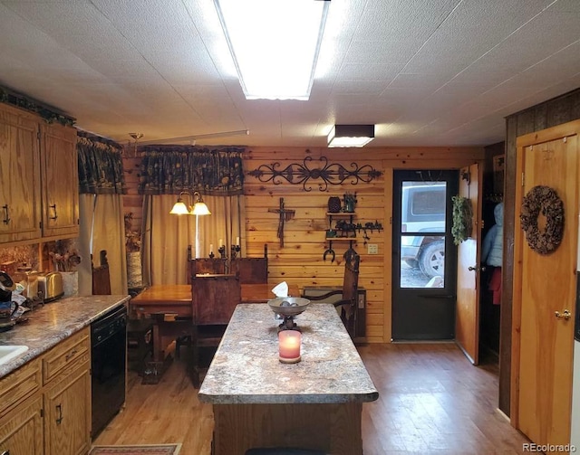 22585 County Road 292, Nathrop, CO 81236 - kitchen with black dishwasher, light wood-style floors, wood walls, light countertops, and brown cabinets