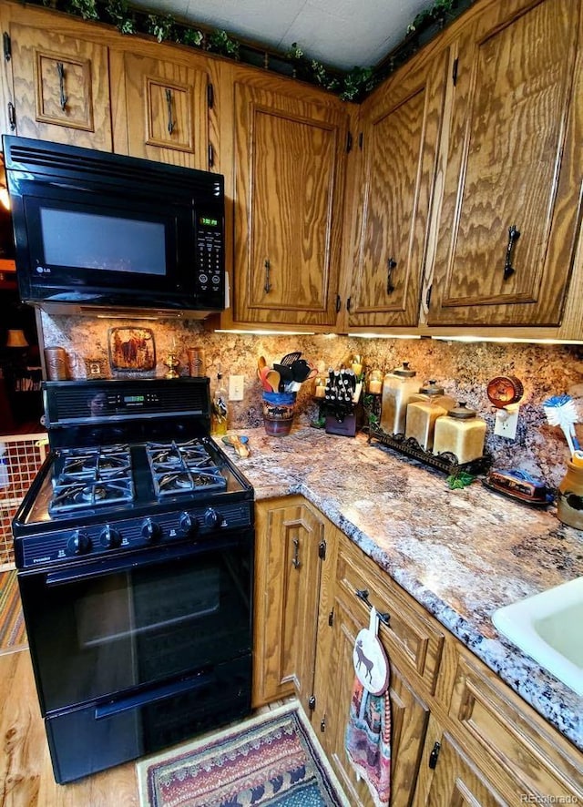 22585 County Road 292, Nathrop, CO 81236 - kitchen featuring black appliances, tasteful backsplash, brown cabinetry, and light stone countertops