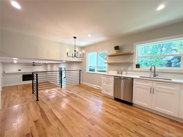 7160 E Iliff Ave, Denver, CO 80224 - kitchen with stainless steel dishwasher, white cabinetry, light wood finished floors, light countertops, and a chandelier