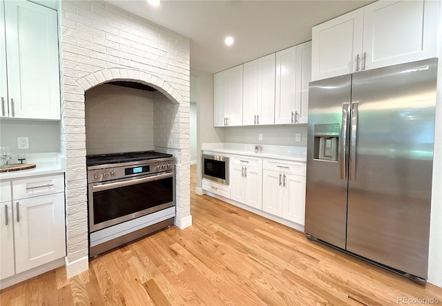 7160 E Iliff Ave, Denver, CO 80224 - kitchen with appliances with stainless steel finishes, light countertops, white cabinetry, light wood-style flooring, and recessed lighting