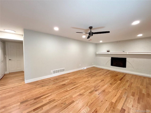 7160 E Iliff Ave, Denver, CO 80224 - unfurnished living room with a fireplace with raised hearth, ceiling fan, light wood finished floors, and recessed lighting