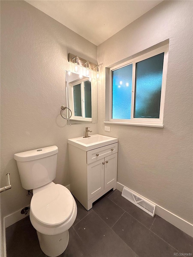 7160 E Iliff Ave, Denver, CO 80224 - half bathroom featuring vanity, tile patterned flooring, and a textured wall