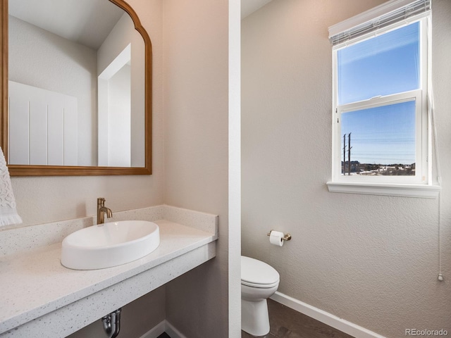 bathroom with sink, hardwood / wood-style floors, and toilet