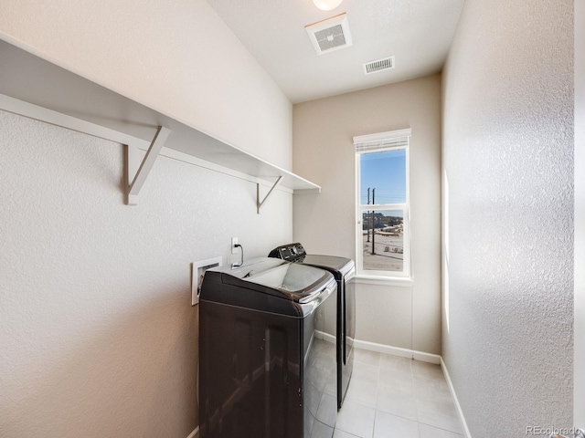 laundry room featuring light tile patterned floors and washer and dryer