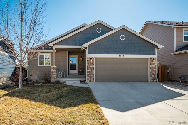 craftsman-style house featuring a garage, concrete driveway, stone siding, and a front lawn