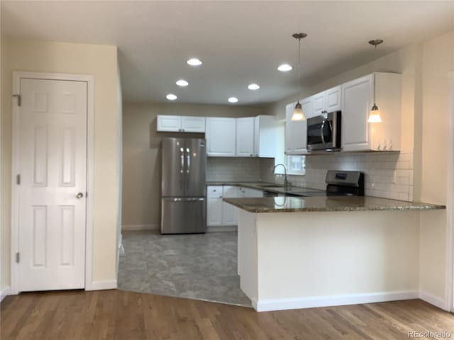 1152 S Eaton St, Lakewood, CO 80232 - kitchen featuring stainless steel appliances, a peninsula, recessed lighting, baseboards, and pendant lighting
