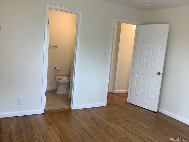 1152 S Eaton St, Lakewood, CO 80232 - unfurnished bedroom with wood finished floors, baseboards, and ensuite bathroom
