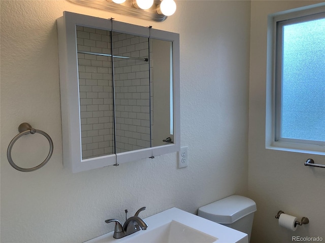 1152 S Eaton St, Lakewood, CO 80232 - full bathroom featuring toilet, a textured wall, vanity, and a tile shower