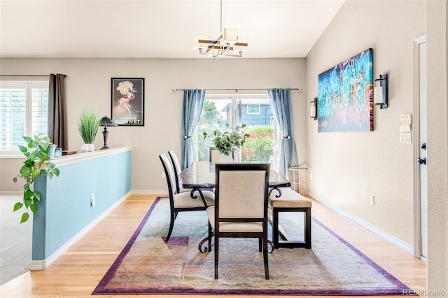 dining area featuring wood-type flooring, a chandelier, and a healthy amount of sunlight