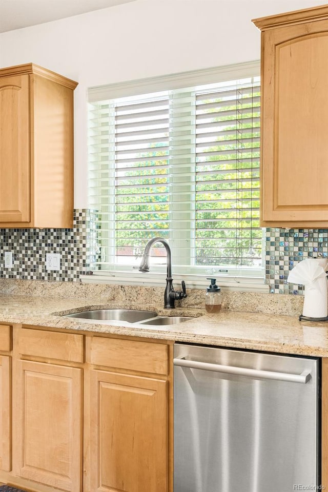 kitchen with stainless steel dishwasher, sink, decorative backsplash, and light brown cabinets