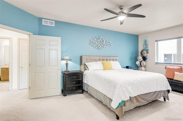 carpeted bedroom with ceiling fan and ensuite bath