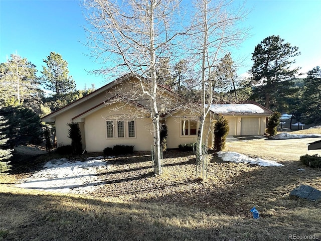 view of front of house featuring concrete driveway, a garage, and stucco siding