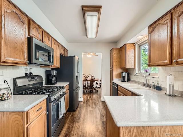11707 W 65th Cir, Arvada, CO 80004 - kitchen with appliances with stainless steel finishes, a sink, decorative backsplash, and dark wood-style flooring