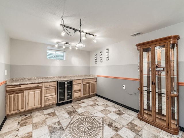 11707 W 65th Cir, Arvada, CO 80004 - kitchen featuring beverage cooler, light countertops, baseboards, and light stone finish flooring