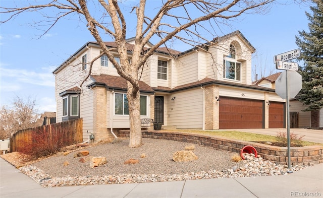 view of front facade with brick siding, driveway, and an attached garage